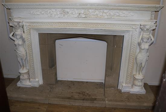 A painted carved wood fire surround with stone insert and plinth, Overall W.232cm H.136cm